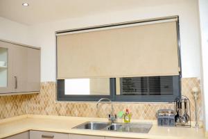 a kitchen with a sink and a window with a window shade at Premier Place, Sky Suites in Accra +45 photos