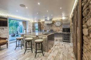 a kitchen with a large island with bar stools at Libertine in Breage