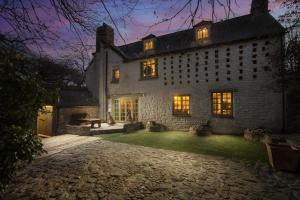 an exterior view of a large stone house at night at Libertine in Breage