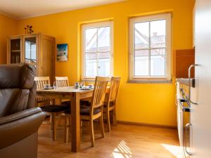 a kitchen with a table and chairs and yellow walls at Gerlach in Zingst