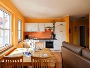 a kitchen with a wooden table and a dining room at Gerlach in Zingst