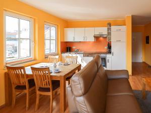 a living room with a table and a couch and a kitchen at Gerlach in Zingst