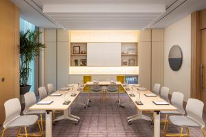 a conference room with long tables and chairs at Bloom Arjaan by Rotana in Abu Dhabi