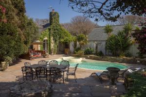 a patio with a table and chairs next to a pool at Libertine in Breage