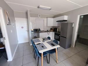 a kitchen with a table and chairs and a refrigerator at 19 on Arch in Langebaan