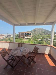 a patio with a table and chairs on a balcony at Hotel Grotte in Mongiove