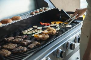 a person cooking meat and vegetables on a grill at ENINARU East in Otsu +125 photos