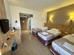a hotel room with two beds and a flat screen tv at Cappadocia Mihran Sultan in Avanos