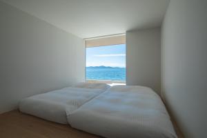 a bed in a room with an ocean view at ENINARU East in Otsu