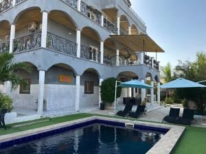 a building with a swimming pool in front of a building at Jozene House in Ngaparou
