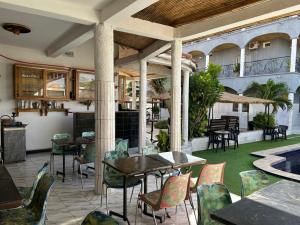 an outdoor patio with tables and chairs and a pool at Jozene House in Ngaparou