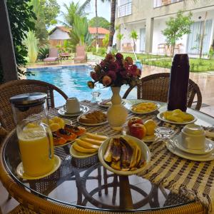 a table with breakfast foods and drinks on it at Pousada Sky Dream Beach Mutá Frente Mar By LVF in Porto Seguro