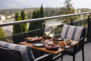 a table with food and glasses of wine on a balcony at Crans Ambassador in Crans-Montana