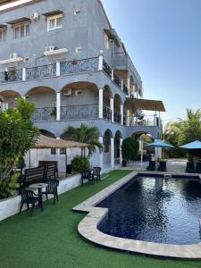 a building with a swimming pool in front of a building at Jozene House in Ngaparou
