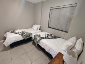 two beds sitting next to each other in a room at 19 on Arch in Langebaan