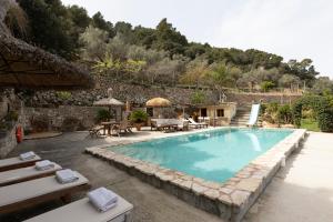 a swimming pool with tables and chairs next to a building at Fabulous Rustic Villa Set On Mountain With Unique Views in Valldemossa