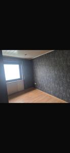 an empty room with a window and a wooden floor at Ferienwohnung Reckerche in Reckershausen
