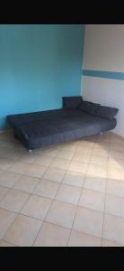 a black bed in a room with a tile floor at Ferienwohnung Reckerche in Reckershausen