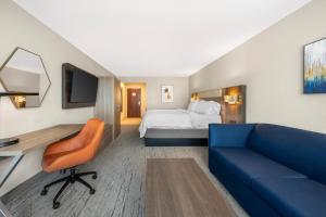 a hotel room with a bed and a blue couch at Holiday Inn Express Selinsgrove by IHG in Shamokin Dam +49 photos
