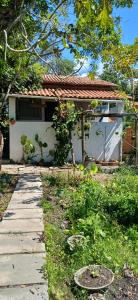 a house with a walkway in front of a yard at Casinha do Pedro próximo ao ponto do trator - Casinha branca in Ilha de Boipeba