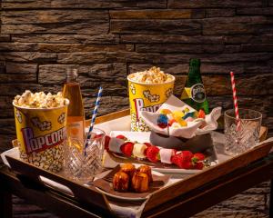 a tray with popcorn and snacks on a table with drinks at Les Manoirs de Tourgéville in Deauville +53 photos