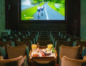 a stage with chairs and a table in front of a screen at Les Manoirs de Tourgéville in Deauville