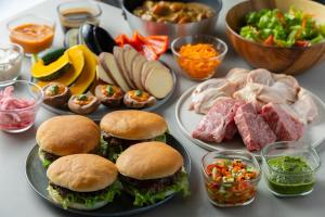 a table topped with plates of food with sandwiches and vegetables at ENINARU East in Otsu