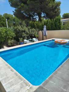 a swimming pool with blue water in a yard at Eco- Refugio Centenario in Sagunto