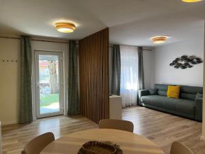 a living room with a table and a couch at Best Apartman Lelle 2 in Balatonlelle +40 photos