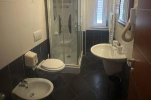 a bathroom with a toilet and a sink and a shower at Hotel Grotte in Mongiove