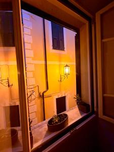 a window view of a building with two potted plants at Ca' Letizia in Noli +14 photos