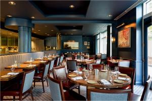 ein Esszimmer mit Holztischen und Stühlen in der Unterkunft Kimpton Marlowe by IHG in Cambridge