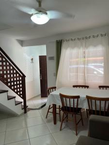 a dining room with a table and chairs and a window at Casas Arraial in Arraial do Cabo