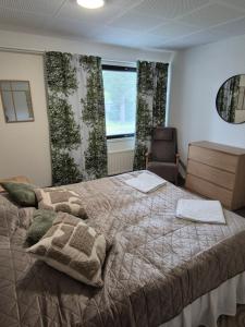 a bedroom with a bed and a chair and a window at Koivutie Best rooms in Ranua +8 photos