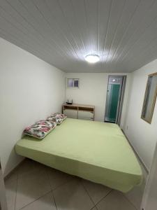 a bedroom with a large green bed in a room at Casas Arraial in Arraial do Cabo +21 photos