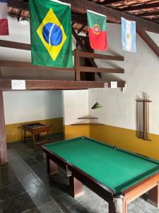 a pool table in a room with flags on the wall at Casas Arraial in Arraial do Cabo