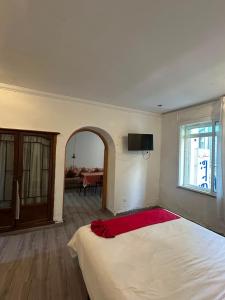 a bedroom with a white bed with a red blanket at Hotel Astoria Tanger in Tangier