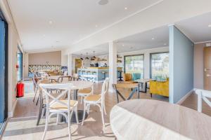 a restaurant with tables and chairs and a kitchen at Lodge 69 at Riviera Bay Coastal Retreat in Brixham