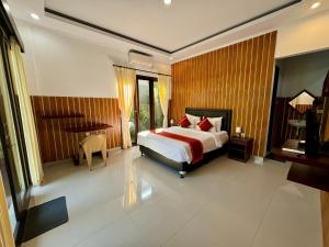 a bedroom with a bed and a desk in it at Ramantika Sunset Bay in Nusa Dua