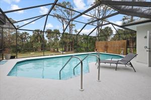a swimming pool with a chair next to it at Palm Tree Parasdise in Englewood