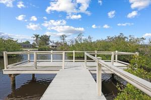 a wooden dock on the water with a blue sky at Palm Tree Parasdise in Englewood +3 photos