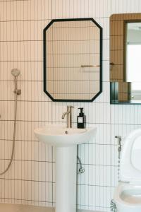 a bathroom with a sink and a mirror and a toilet at 버터인 강릉역 중앙시장 월화거리 교리단길 도보 10분 in Gangneung