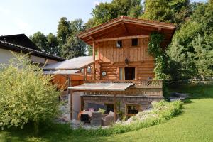 eine Blockhütte mit Veranda und Terrasse in der Unterkunft Schlossalm Ferienwohnungen in Brannenburg