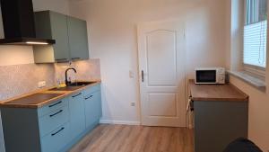 a kitchen with a sink and a microwave on a counter at Apartment 2 Unter den Eichen in Tätendorf-Eppensen +5 photos