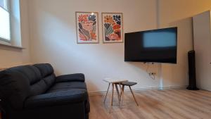a living room with a couch and a flat screen tv at Apartment 2 Unter den Eichen in Tätendorf-Eppensen
