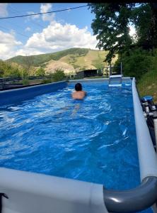 a man in a swimming pool on a water slide at Casa Kaf in Sebeşel