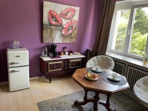 a living room with a table and a purple wall at Gemütlicher Oase mit eigenen Bad in Zentrale, jedoch ruhige Lage in Mönchengladbach