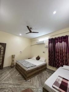 a bedroom with two beds and a ceiling fan at Annapurna Homestays in Varanasi +10 photos