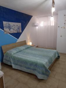 a bedroom with a bed and a blue wall at Appartamento Tavernetta Corallo Rosso in Isca Marina