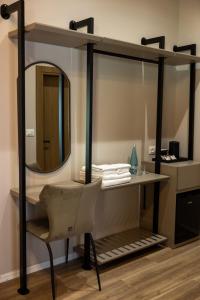 a mirror and a desk with a chair in a room at KAÑ Inn in Vlorë +94 photos